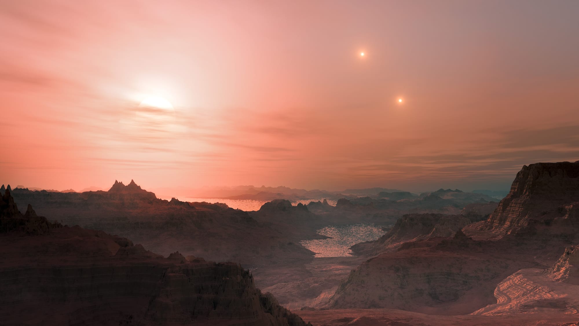 A near-sunset view with mountains and the sea beyond, as imagined for an exoplanet in a system of three suns. The other two distant suns shine to the right of the big one about to set.